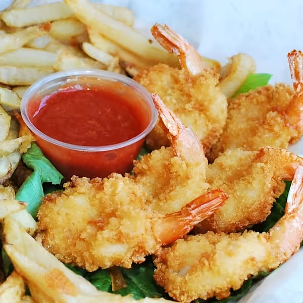 Crispy fried shrimp and french fries with a side of red cocktail sauce at Moody's Pub.