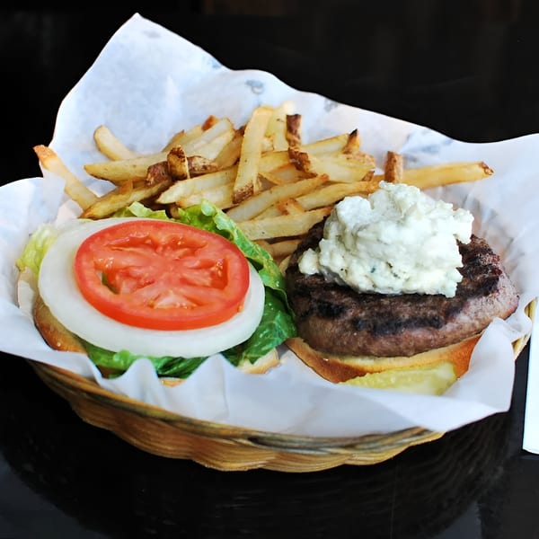 A Moody's Pub burger with blue cheese, lettuce, tomato, onion, and a side of fries.