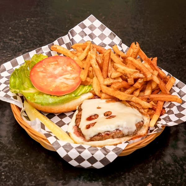 A Moody's Pub cheeseburger with lettuce, tomato, fries, and a pickle spear in a basket.